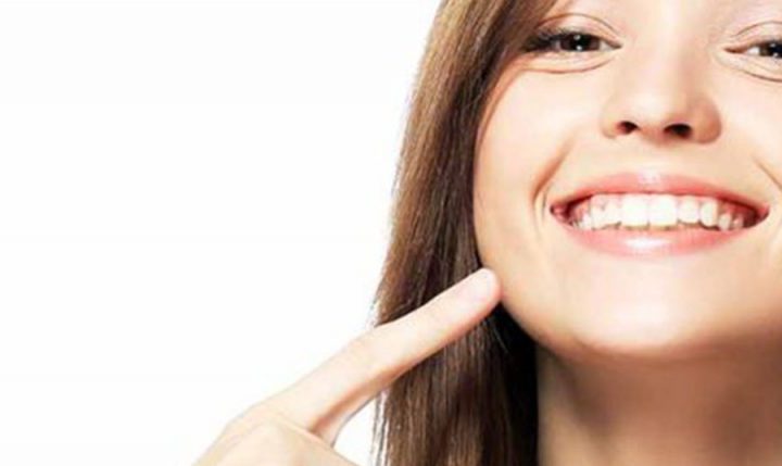 young female patient smiling pointing to teeth